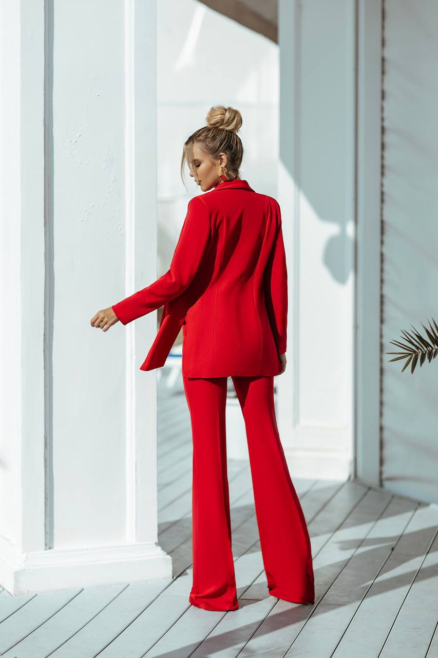 Person wearing a red outfit standing in a bright, minimalistic room.
