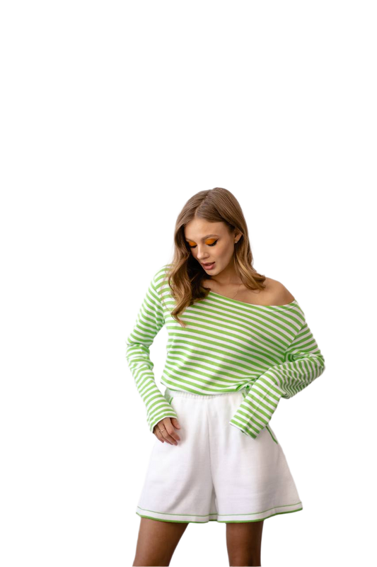 Woman wearing a green and white striped sweater and white skirt on a white background