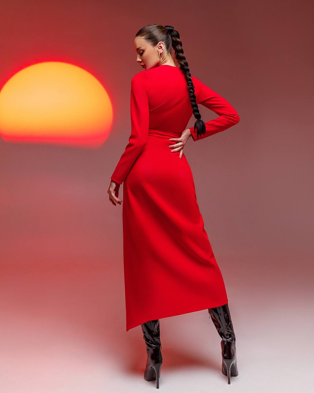 Woman in a red dress with a sun-like object in the background