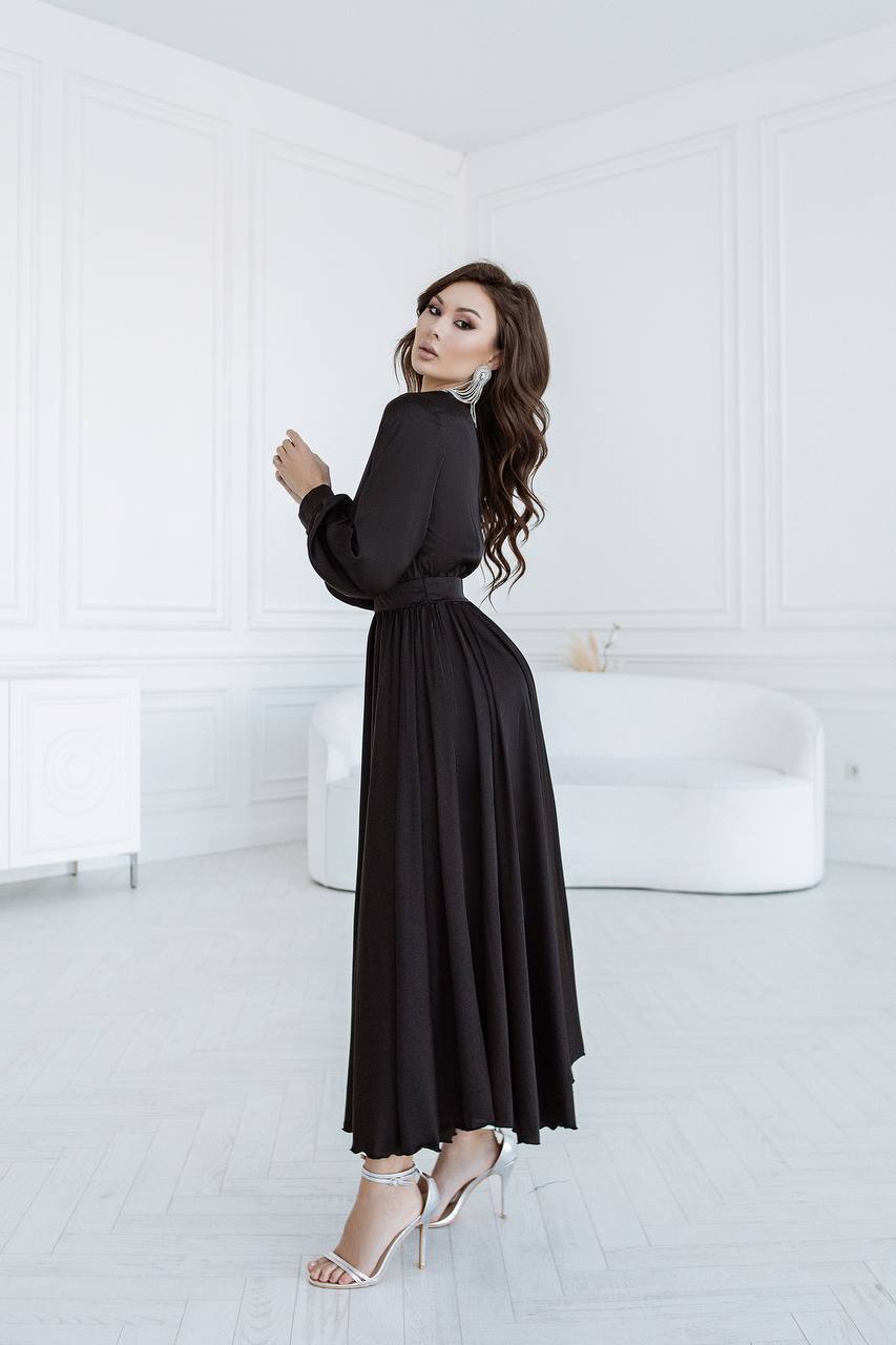 Woman wearing a black dress in a minimal white room