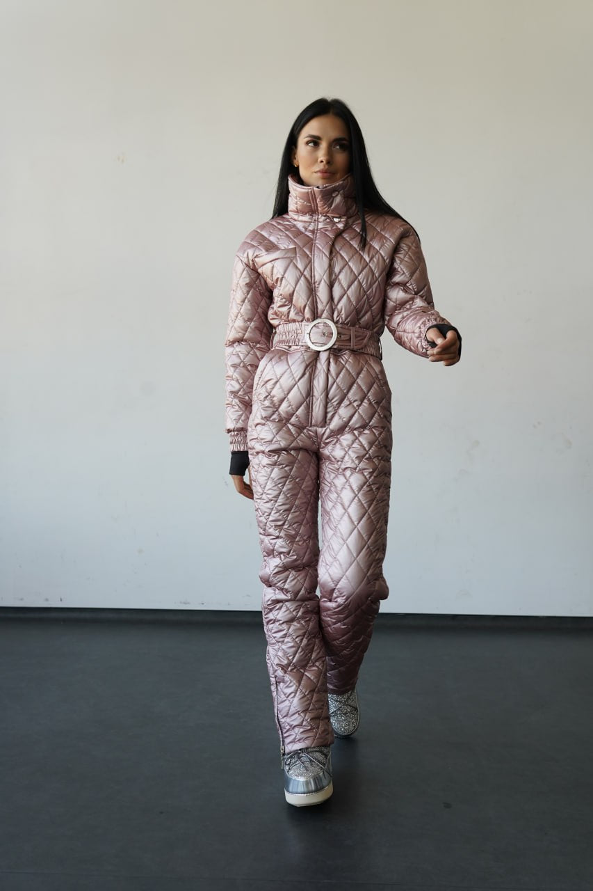 Person wearing a pink quilted snowsuit against a plain background