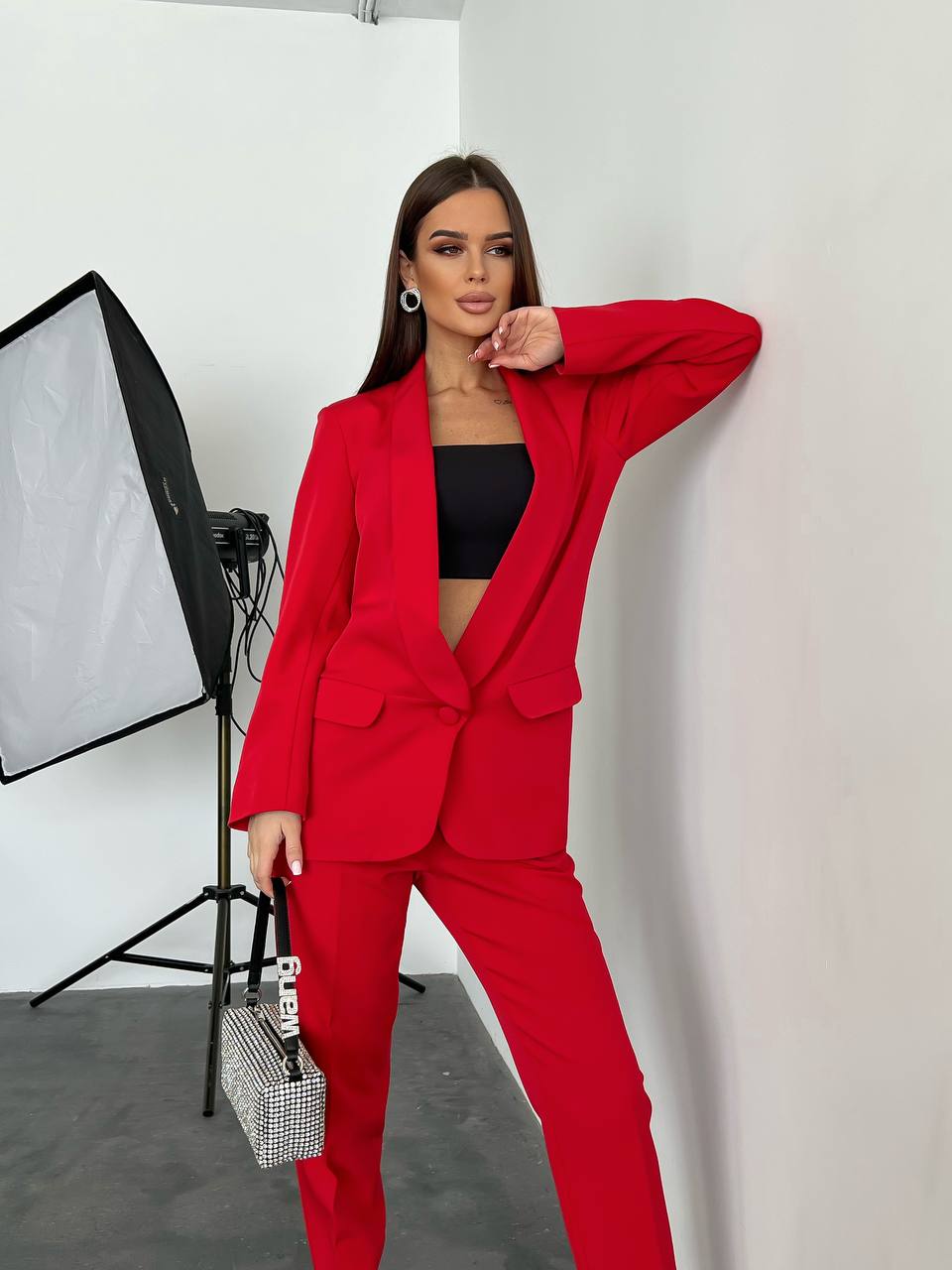 Woman in a red suit posing in a studio setting