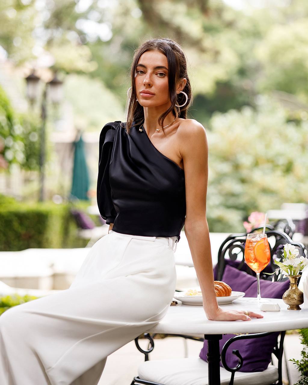 Woman sitting at an outdoor table with a scenic background