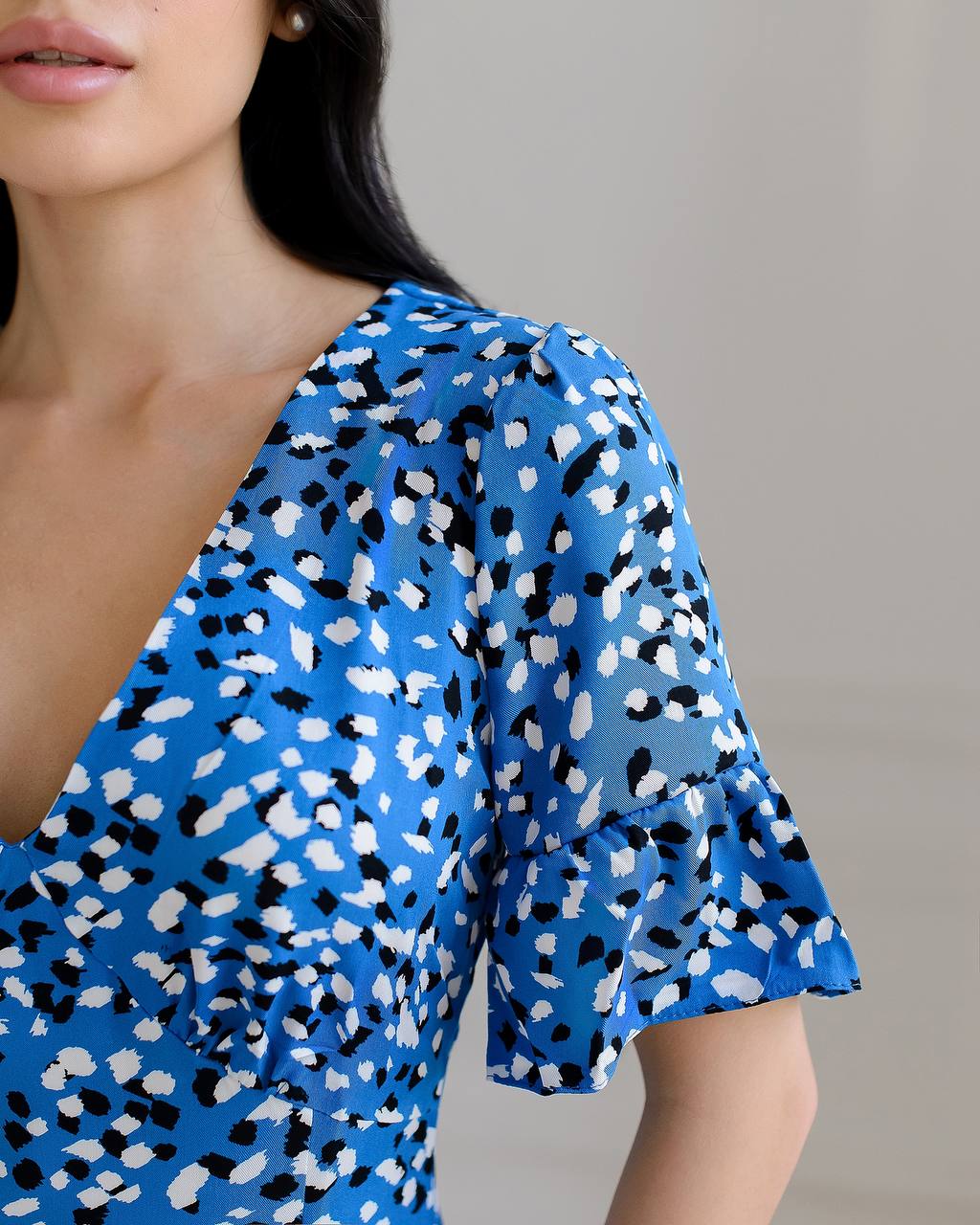 Blue dress with black and white pattern worn by a person against a neutral background