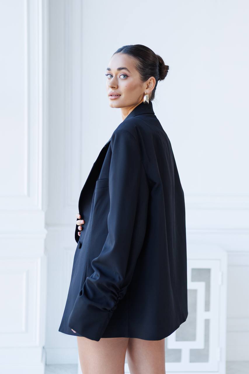 Woman wearing a black blazer against a light background