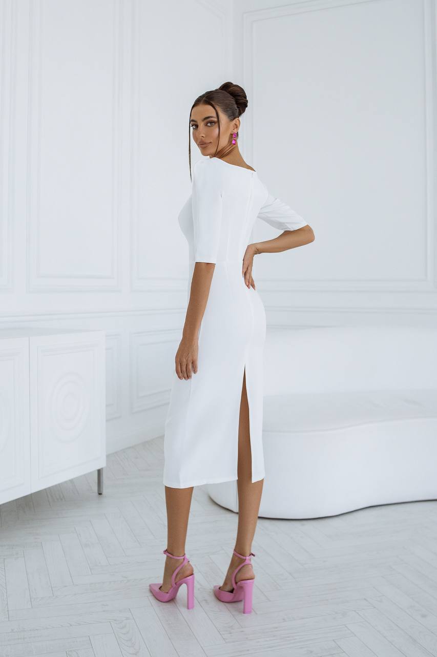 Woman wearing a white dress with a high slit in a minimalistic setting