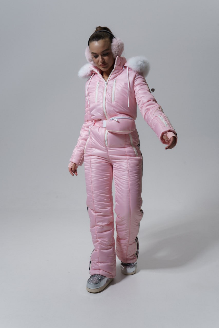 Person wearing a pink snowsuit with fur trim on a gray background