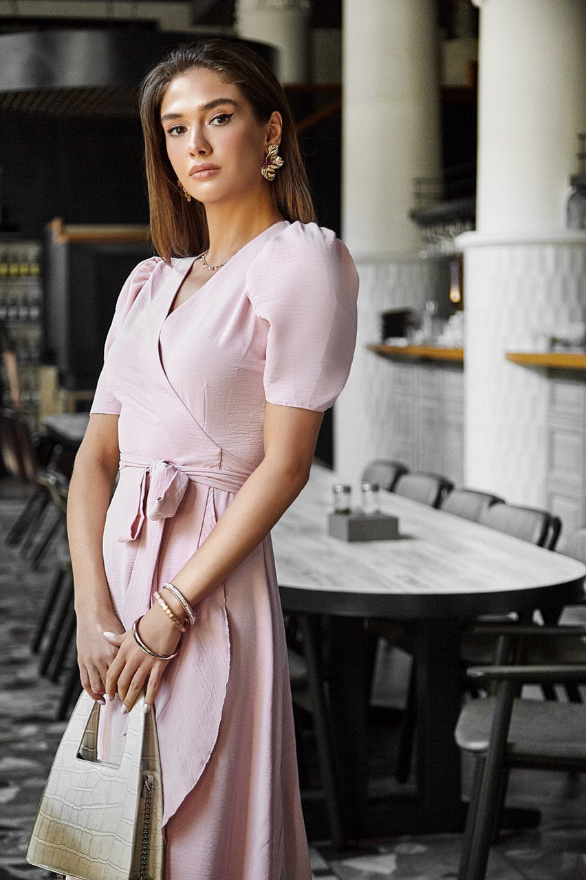 Woman in a pink dress standing in a restaurant setting