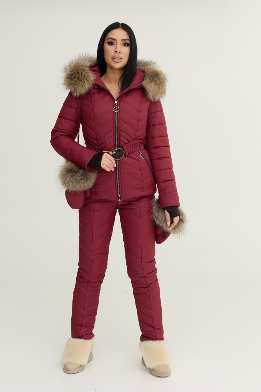 Person wearing a red puffer suit with fur trim on a white background