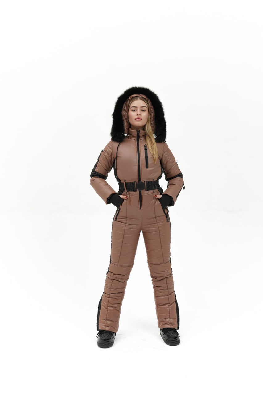 Person wearing a brown quilted jumpsuit with a hood on a white background