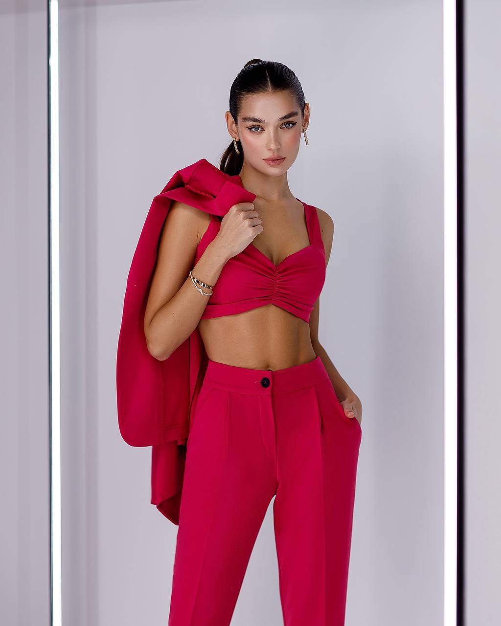 Woman wearing a bright pink outfit against a white background