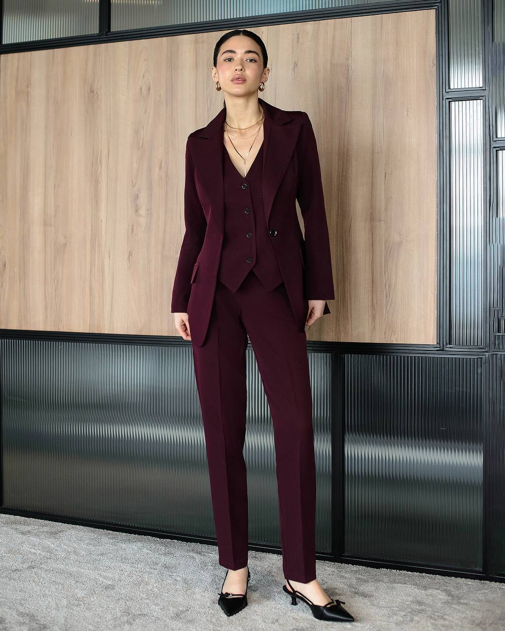 Woman wearing a burgundy suit standing in an office setting