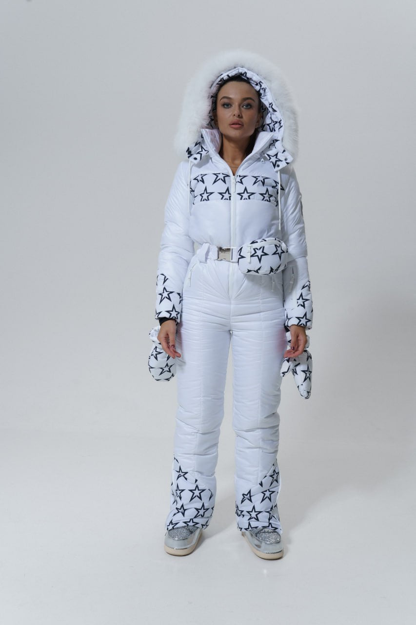 Woman wearing a white snowsuit with star patterns on a plain background