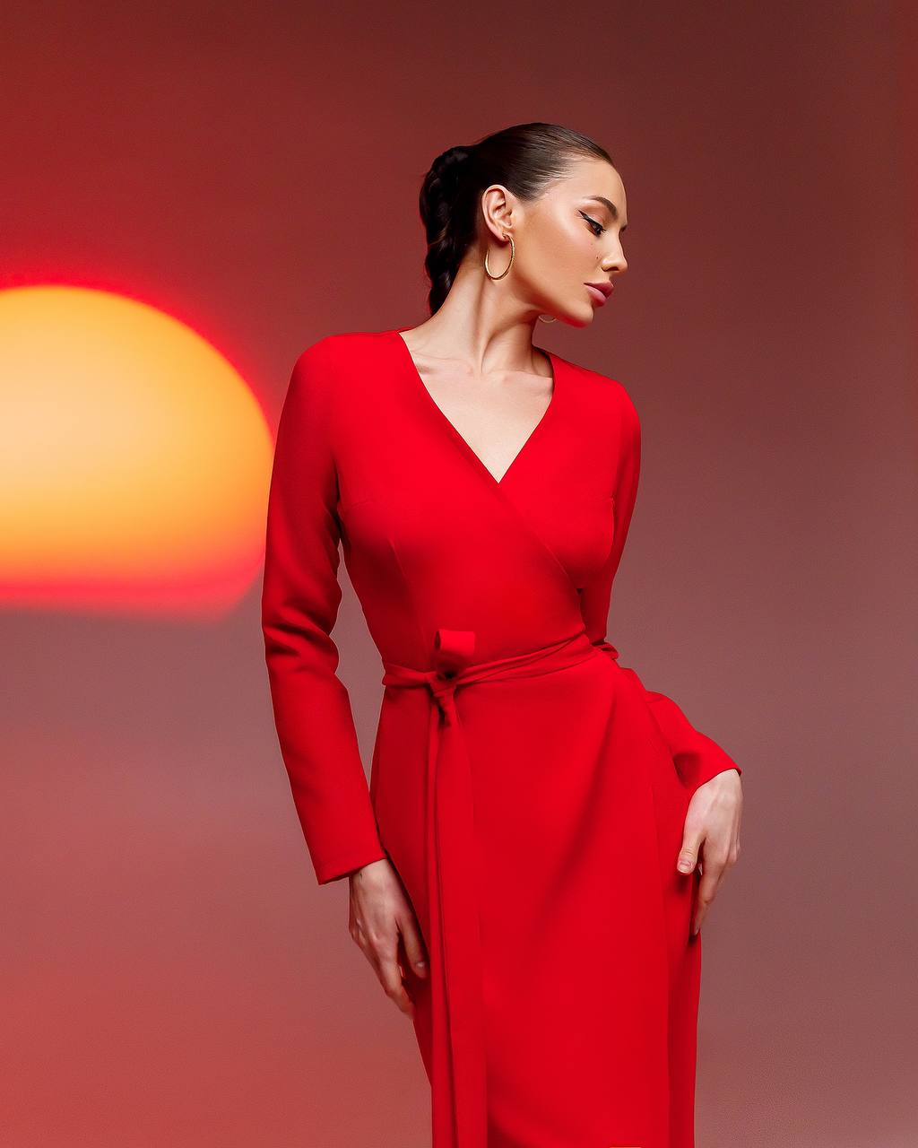 Woman in a red dress against a warm-toned background