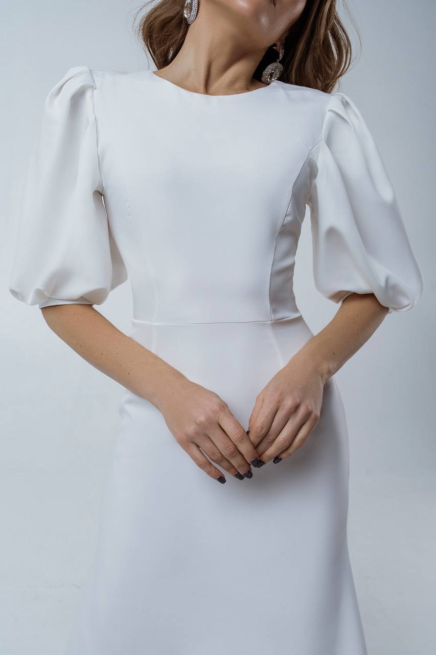 White dress with puffed sleeves on a plain background