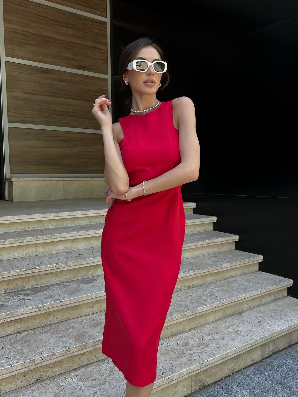 Woman in a red dress standing on steps outdoors