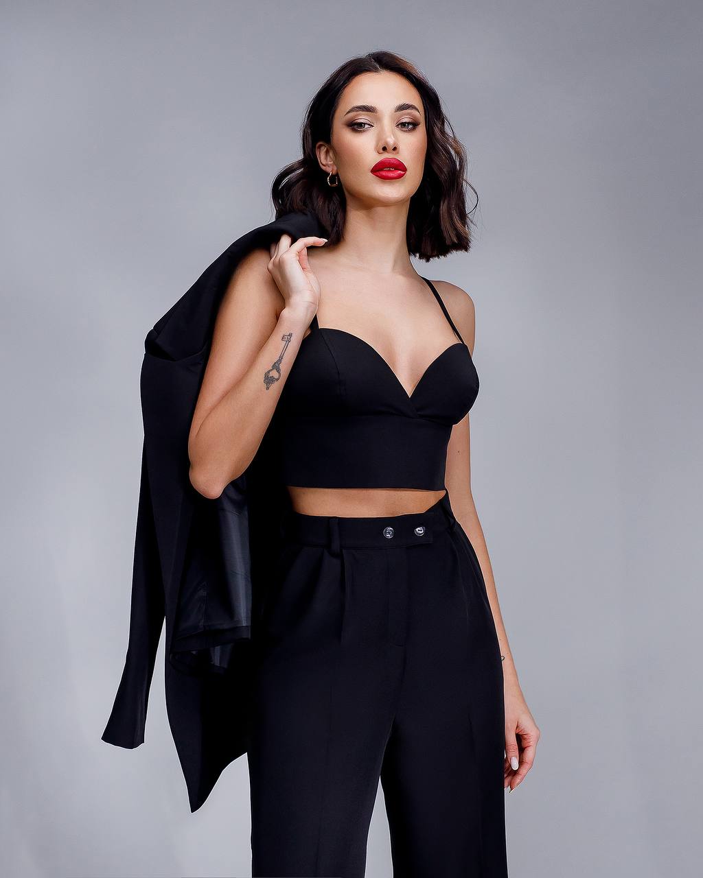 Woman wearing a black outfit with a gray background