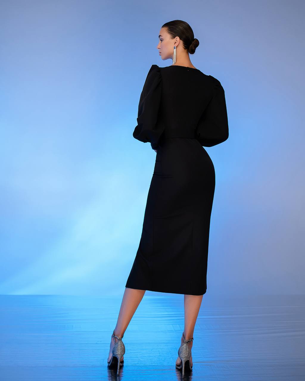 Woman wearing a black dress against a gradient blue background
