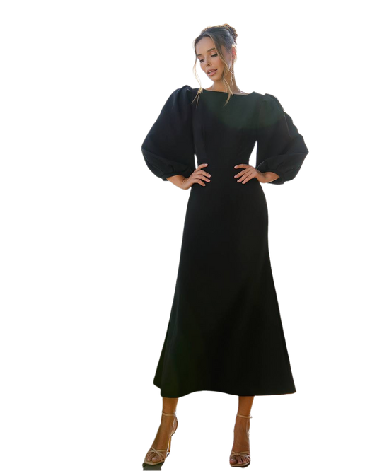 Woman wearing a black dress with puffed sleeves on a white background