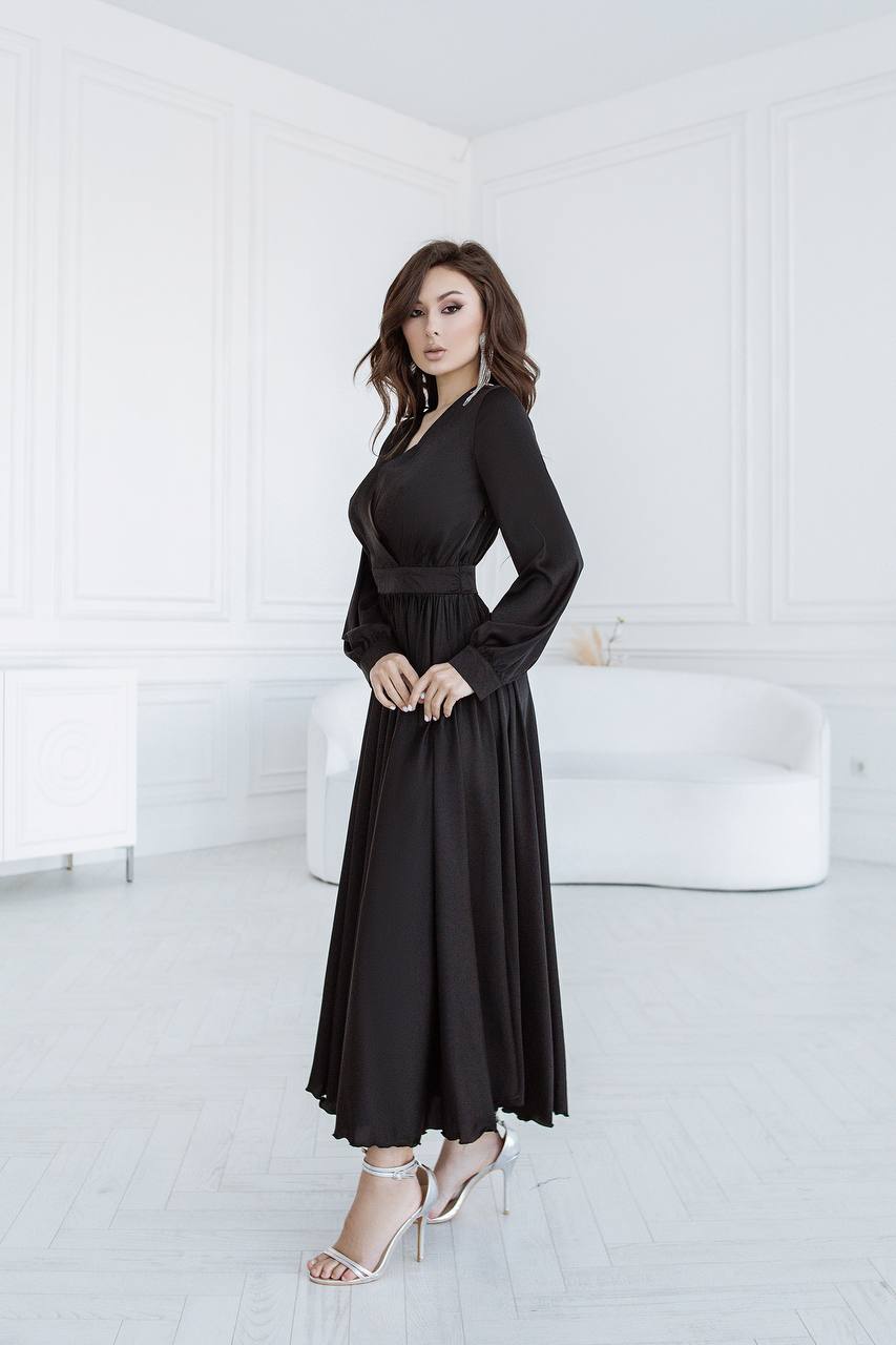 Woman wearing a black dress in a minimal white room