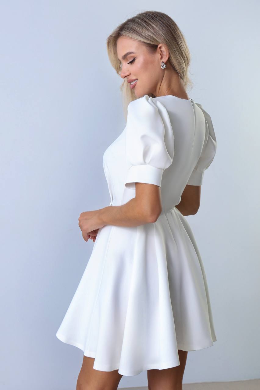 Woman wearing a white dress against a light gray background