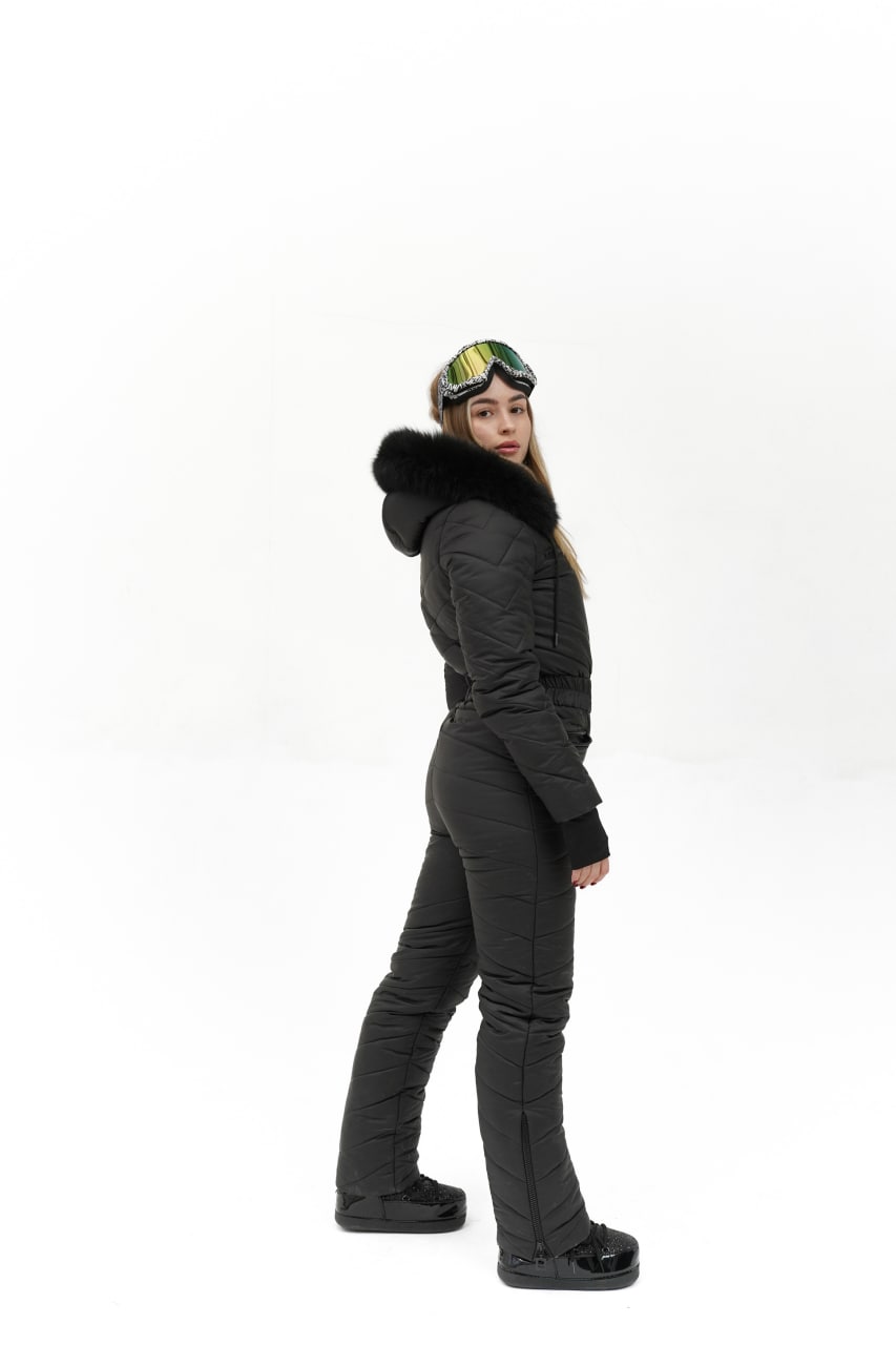 Person wearing a black snowsuit with a hood on a white background