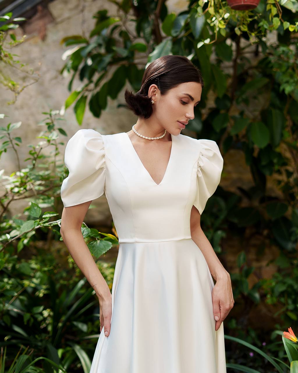 Woman in a white dress standing in a garden setting