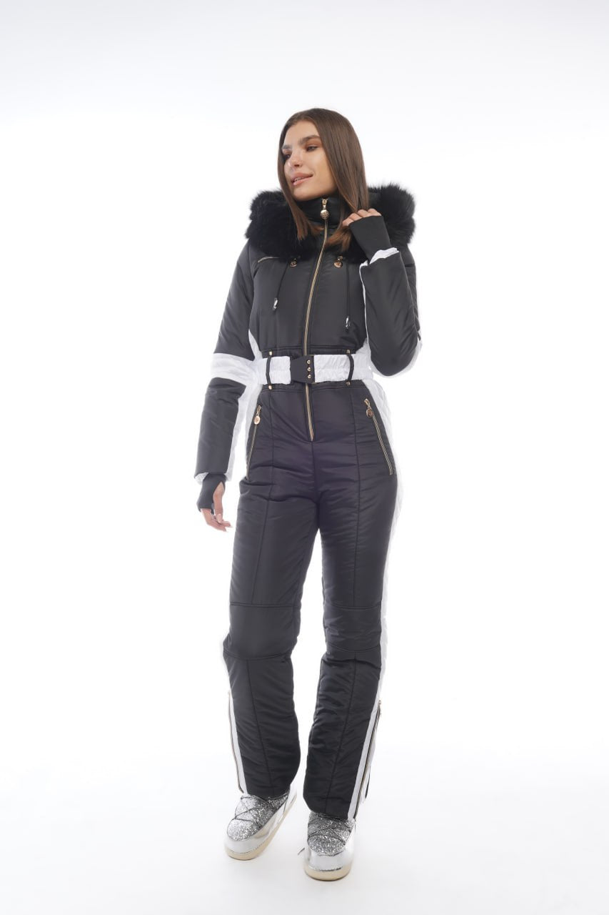 Person wearing a dark gray snowsuit with white accents on a white background