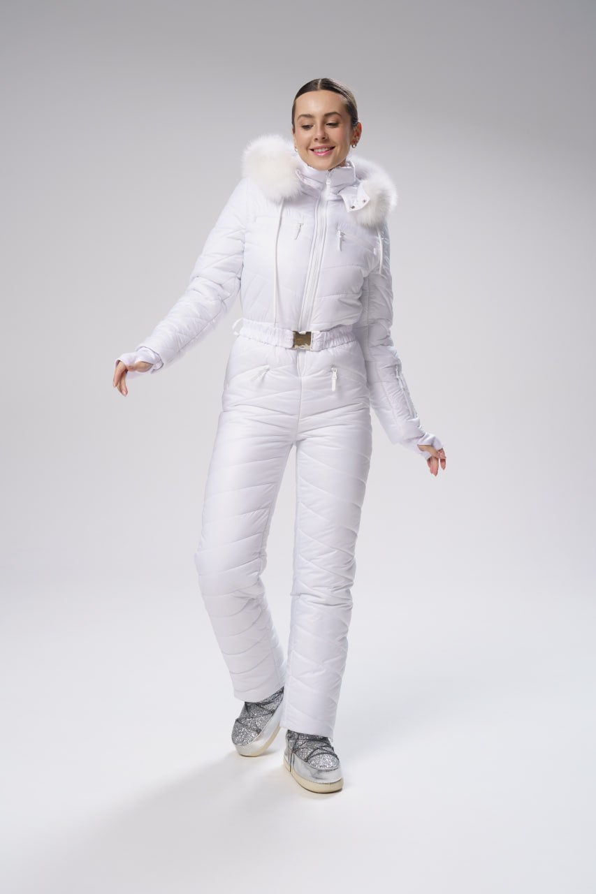 Person wearing a white puffer suit with fur accents on a gray background