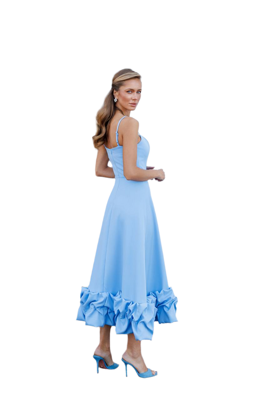 Woman wearing a light blue dress with ruffled hem on a white background