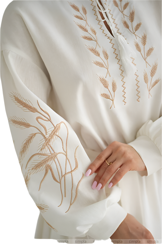 White garment with gold embroidery on a plain background