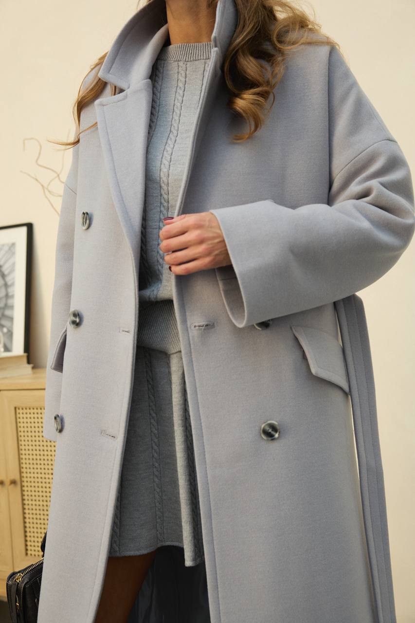 Light blue coat worn by a person indoors with a neutral background