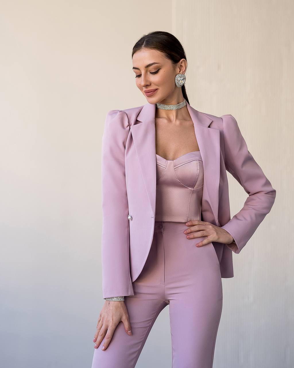 Woman wearing a light purple suit against a plain background