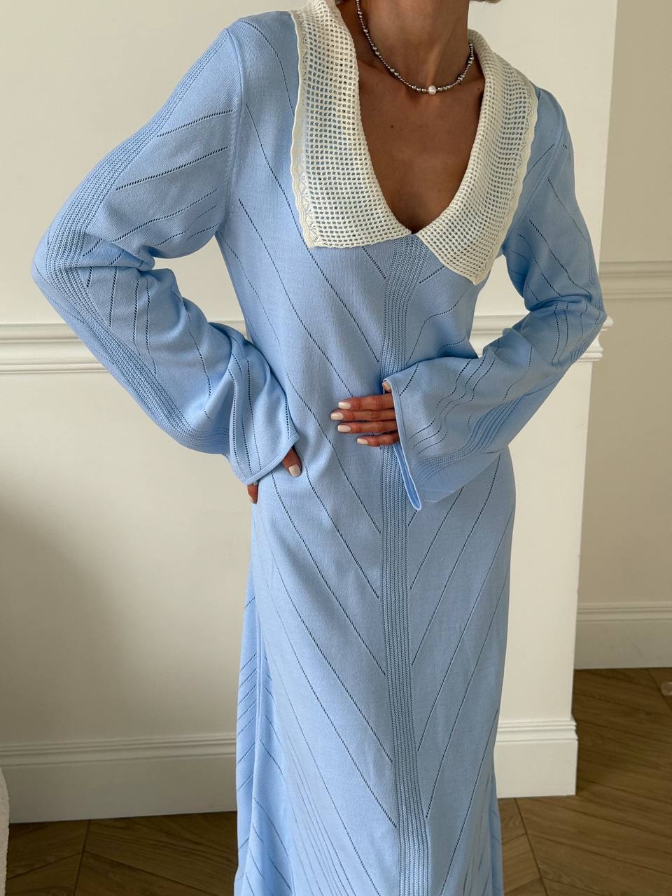 Light blue dress with a textured neckline against a neutral background