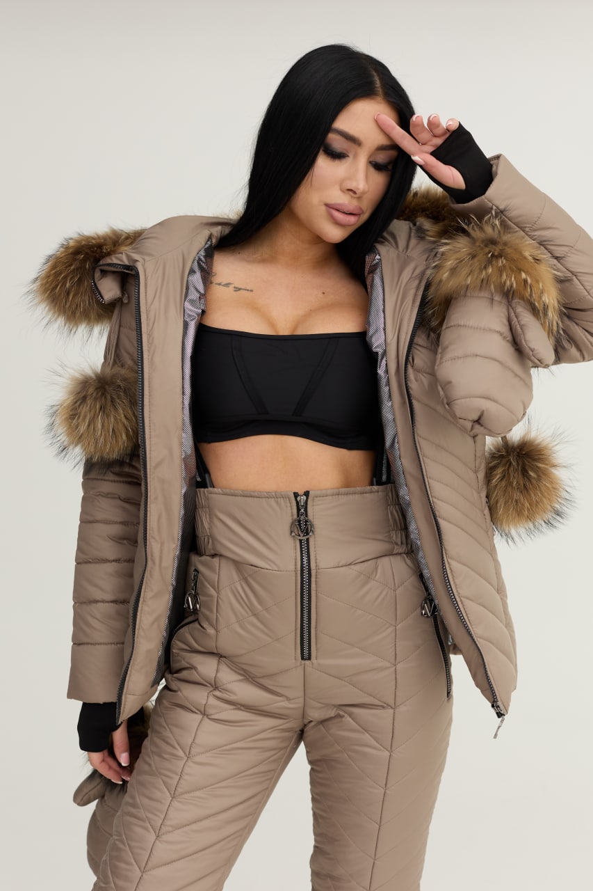 Woman wearing a beige puffer jacket with fur trim on a white background