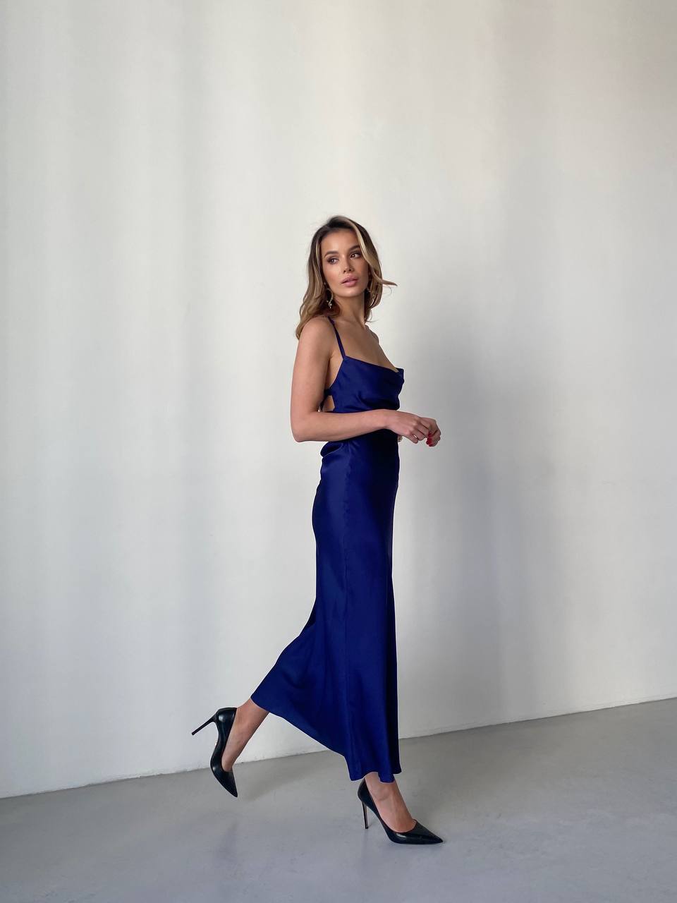 Woman wearing a blue dress against a plain background