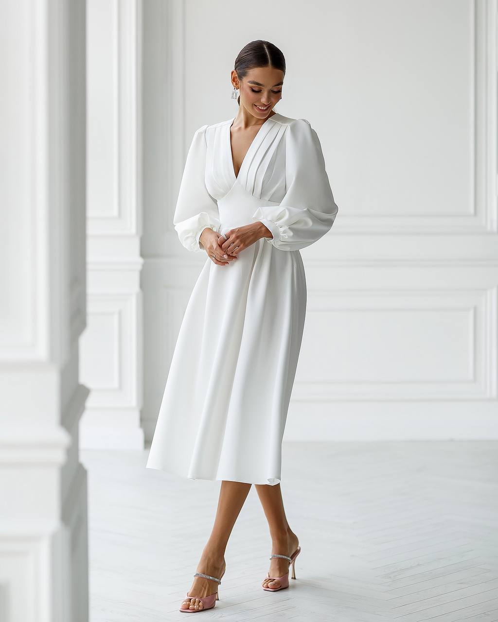 Woman wearing a white dress in a minimalistic setting