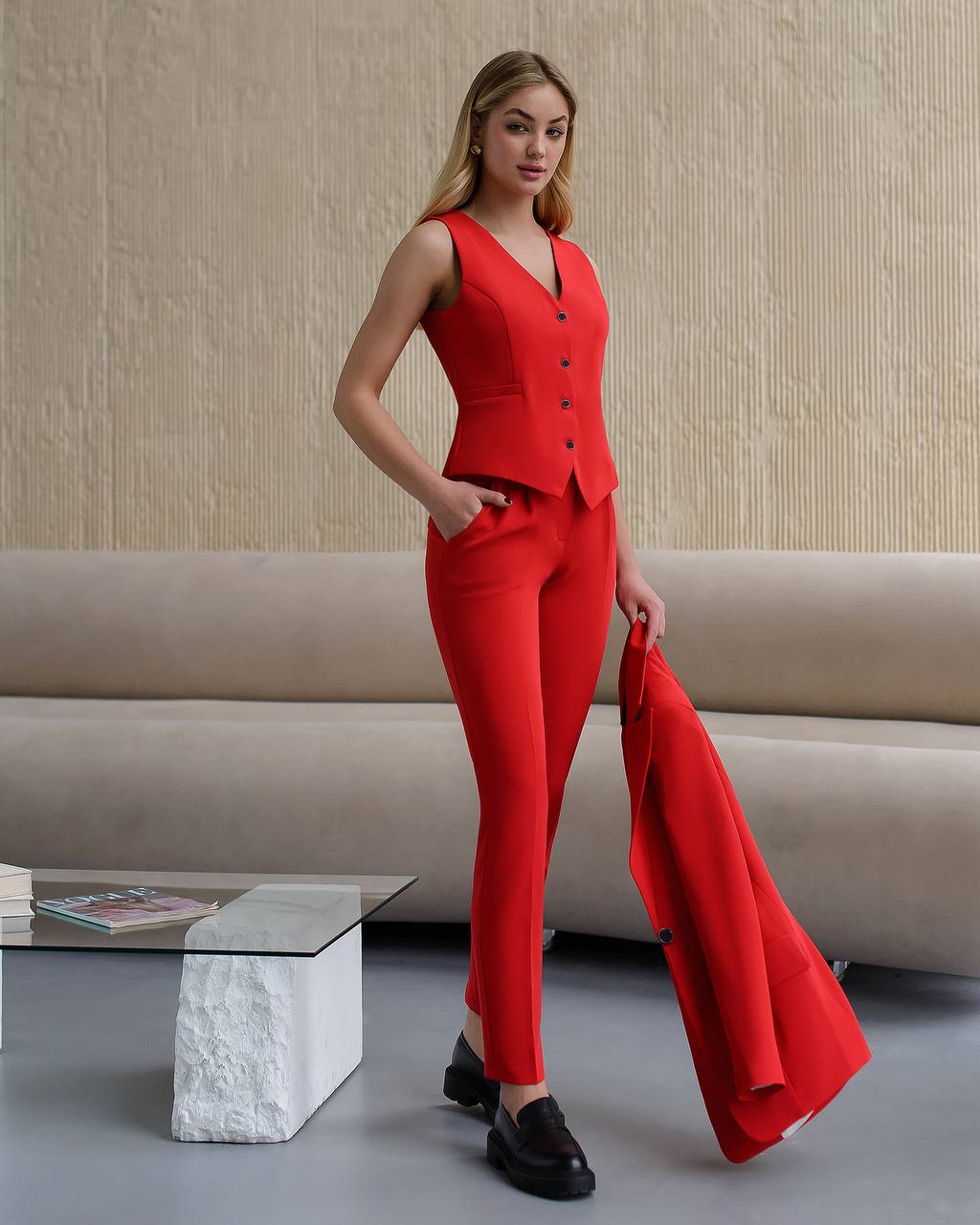 Woman in a red outfit standing in a modern interior setting