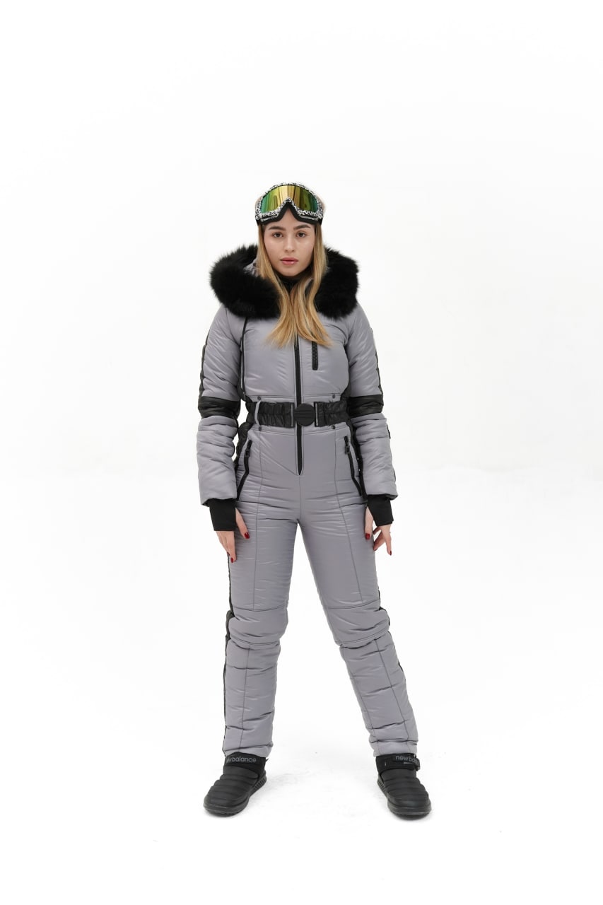 Person wearing a gray ski suit with black accents on a white background
