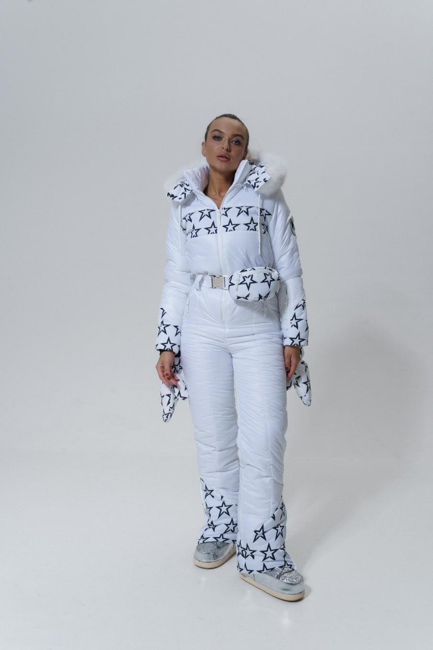 Person wearing a white outfit with star patterns on a plain background