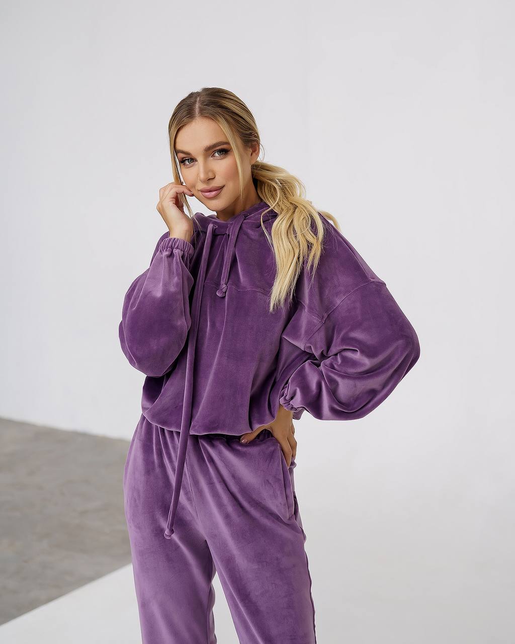 Woman wearing a purple outfit against a white background
