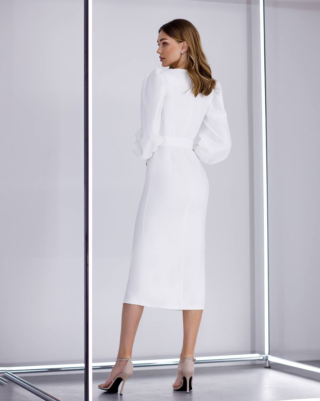 Woman wearing a white outfit in a minimalistic setting