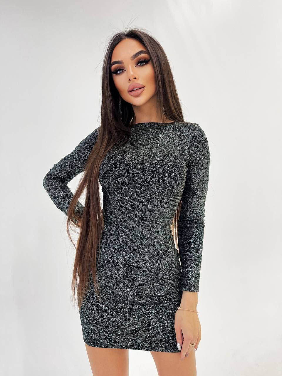 Woman wearing a gray long-sleeve dress against a white background
