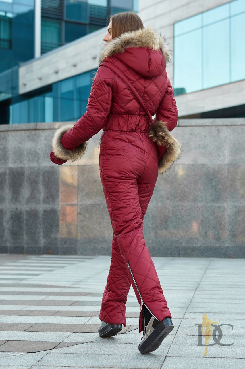 Person wearing a red winter outfit with fur trim in an urban setting