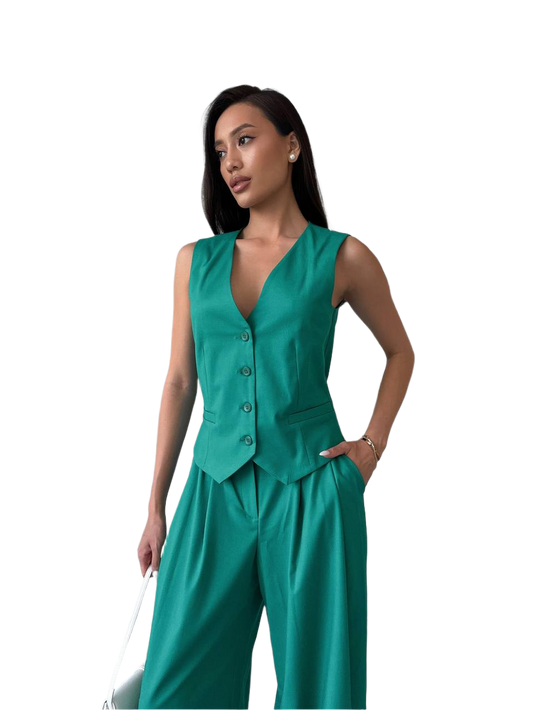 Woman wearing a teal sleeveless top and pants on a white background