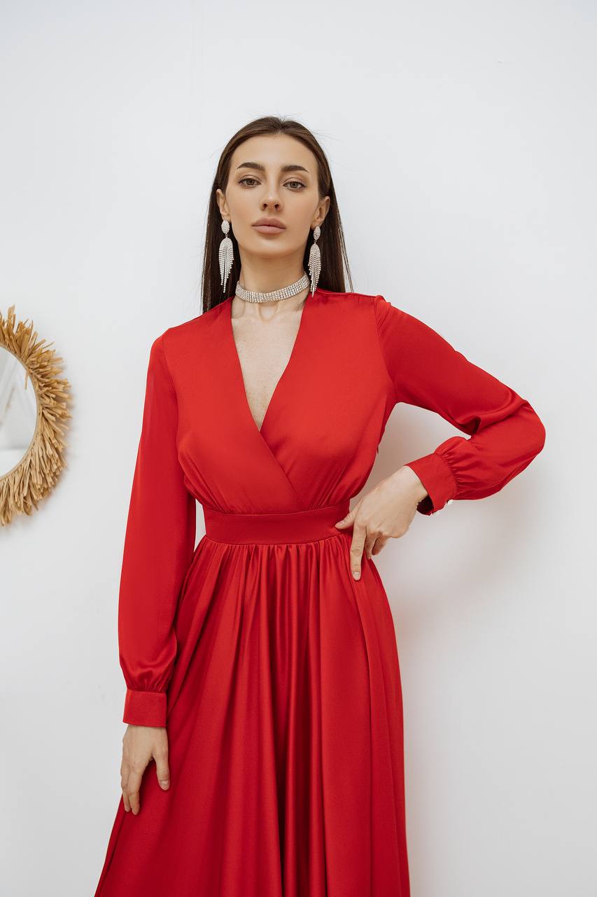 Woman wearing a red dress against a white wall