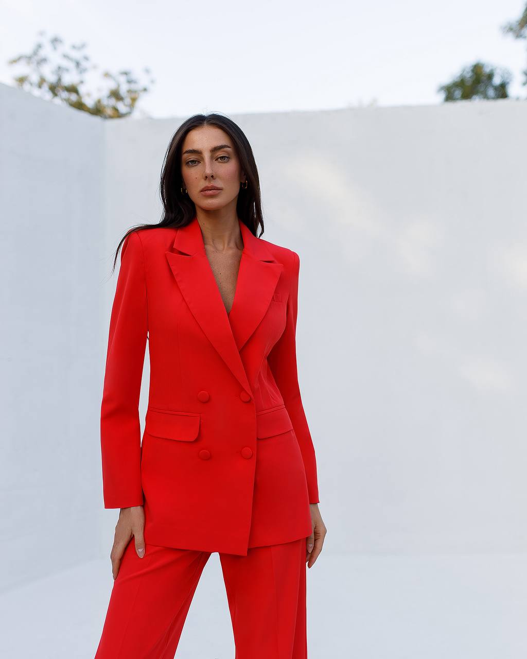 Woman wearing a red suit against a white background