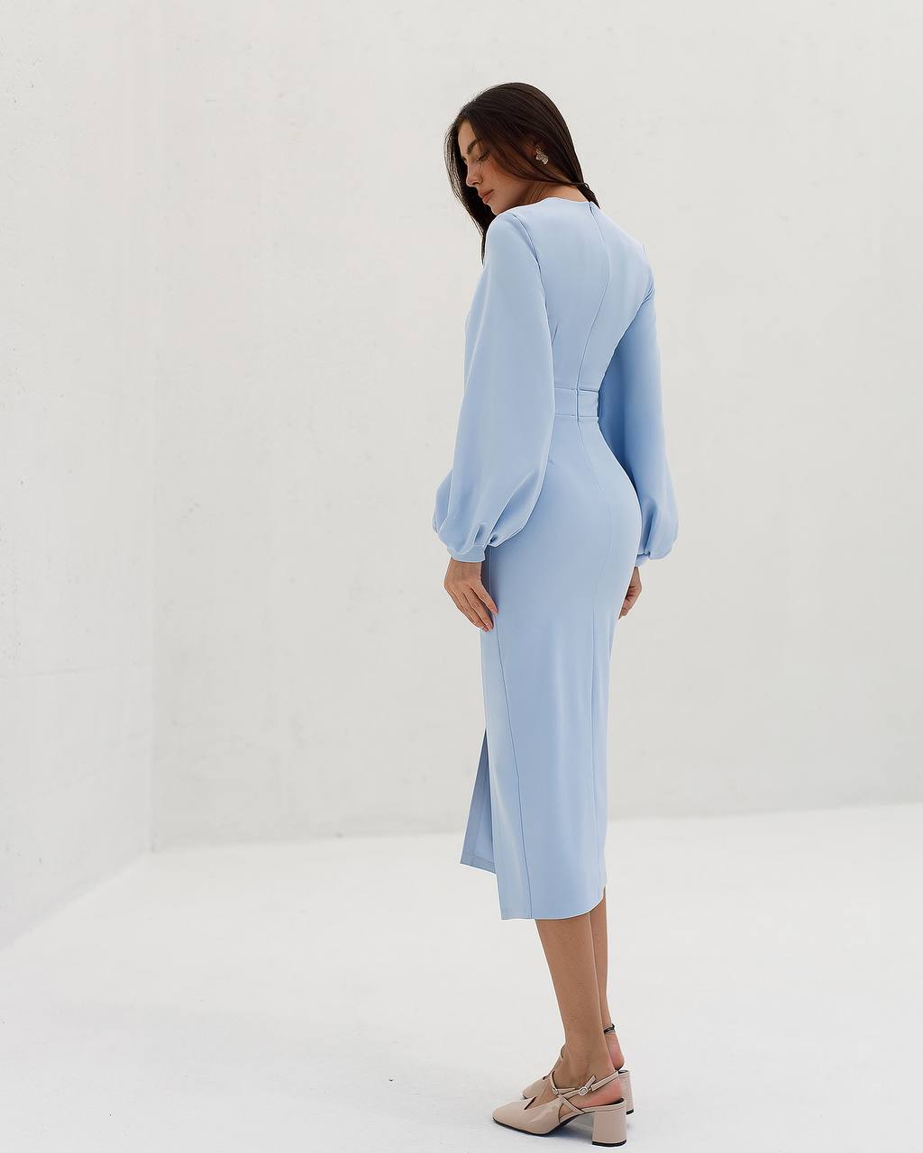 Woman wearing a light blue dress against a white background