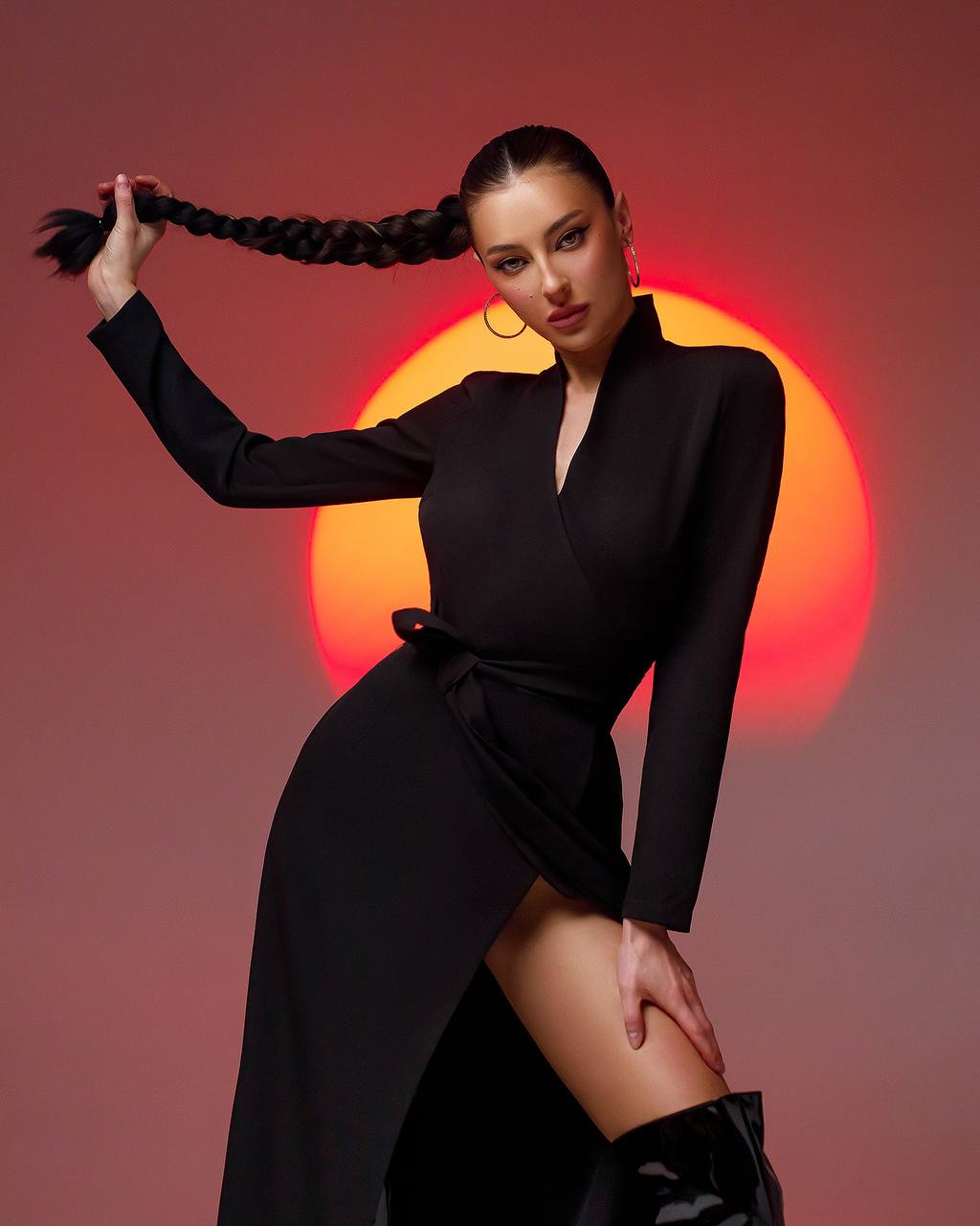 Woman in a black dress with a sunburst background