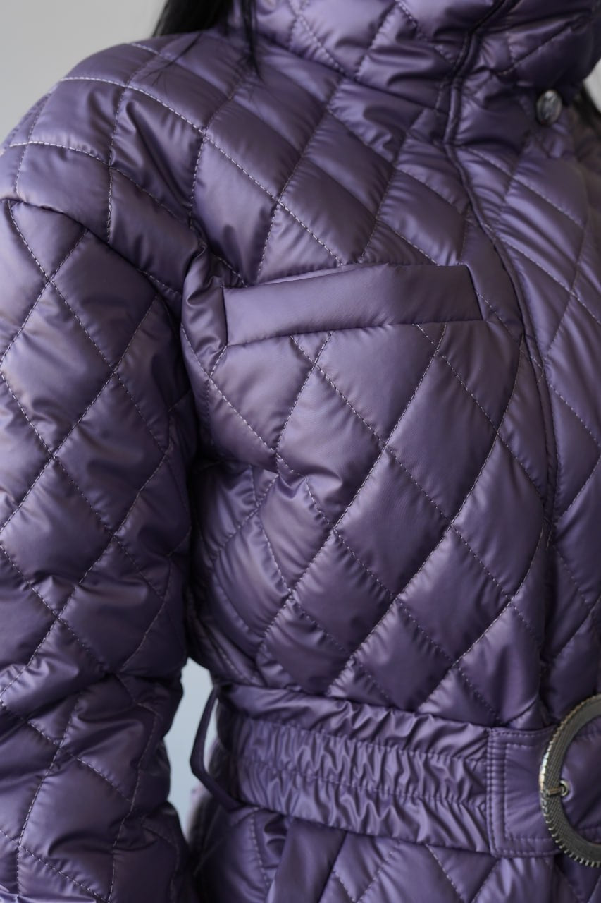 Close-up of a person wearing a purple quilted jacket with a belt.